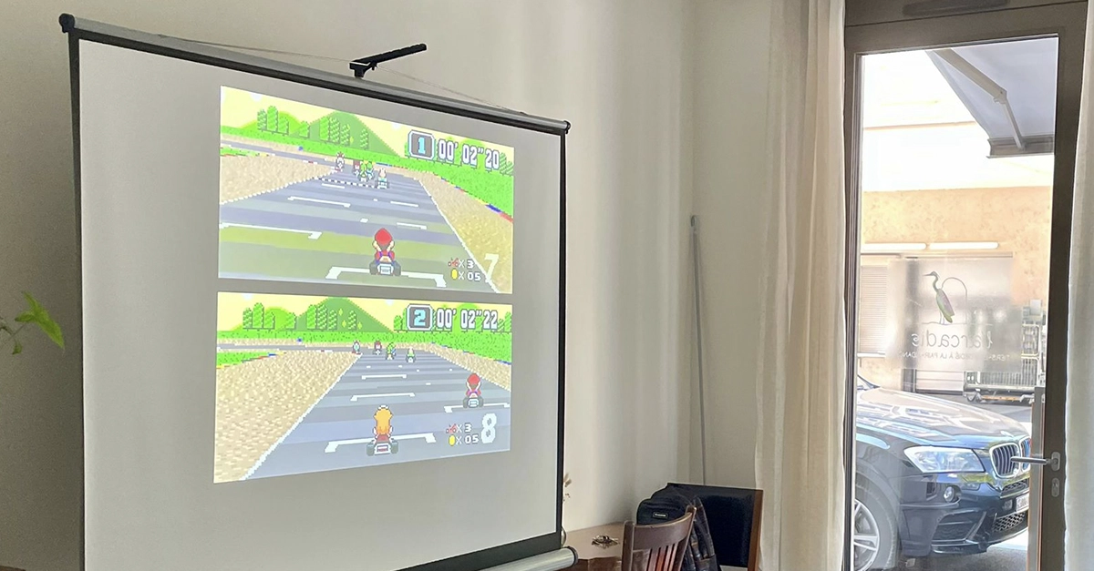 Ecran de projection avec jeu de voiture en fond
